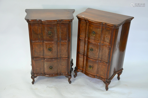 A pair of walnut three drawer chests of serpentine form