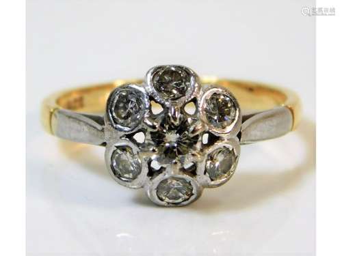 A two colour 18ct gold daisy style ring set with s