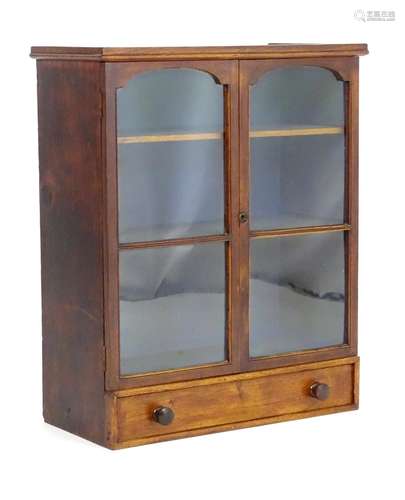 A late 19thC / early 20thC bookcase with two glazed doors above a single long drawer with turned