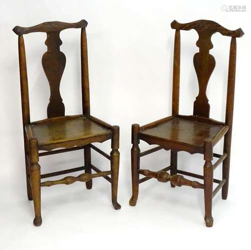 Two early 19thC oak side chairs with shaped top rails and vase shaped splays above turned tapering