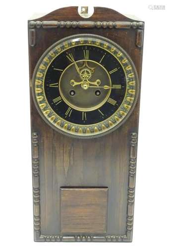 An Edwardian wall clock, the stained oak case housing a black and gilt numeral dial, 17 3/4