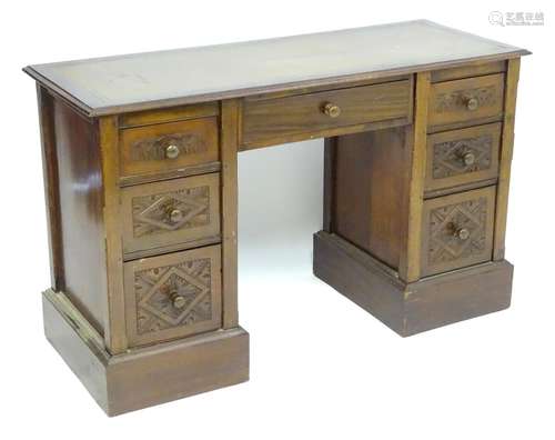 A late 19thC / early 20thC double pedestal desk with an inset leather top above a central long