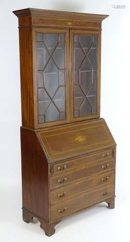 An early 20thC mahogany bureau bookcase with a moulded cornice above two astragal glazed doors and