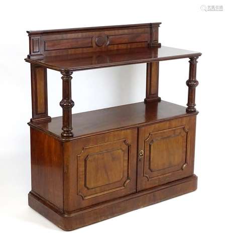 A mid 19thC mahogany buffet with a shaped upstand above two turned fluted supports and panelled