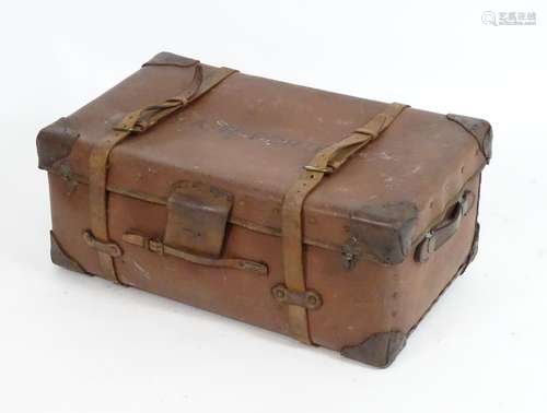 An early 20thC leather trunk with carrying handles to the sides and leather straps. 30