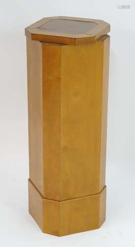 A mid 20thC satin birch pedestal with an octagonal revolving top. Measuring 12