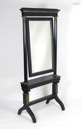 An early 20thC French ebonised cheval mirror, having a moulded cornice above a gilt metal adorned