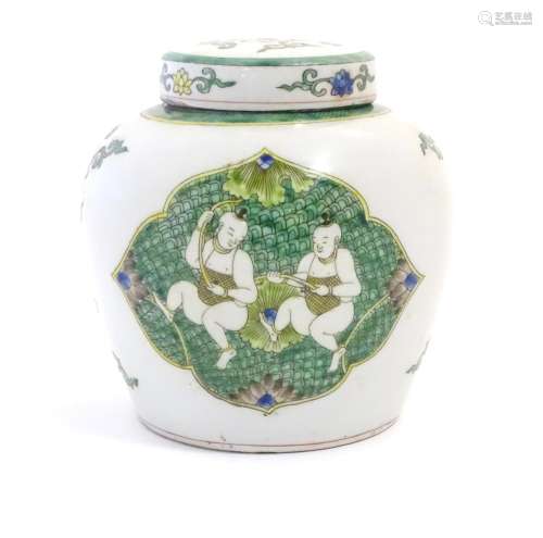A Chinese famille verte ginger jar and cover with panelled decoration depicting figures with