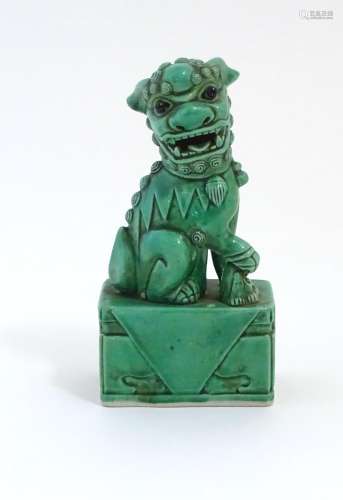 A Chinese model of a seated dog of foo with a green glaze. Approx. 6 3/4