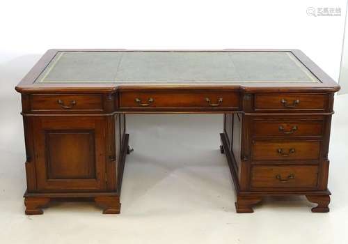 A late 20thC mahogany double pedestal partners desk of large proportions, having a gold tooled