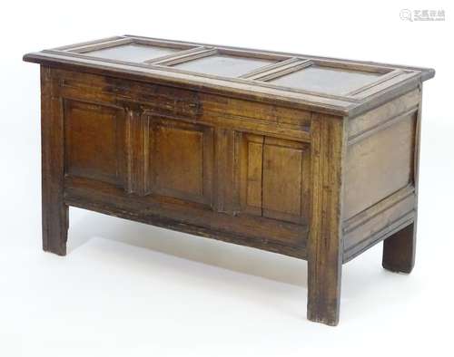 An early 18thC oak coffer with a three panel top and front, having a chamfered, moulded frame