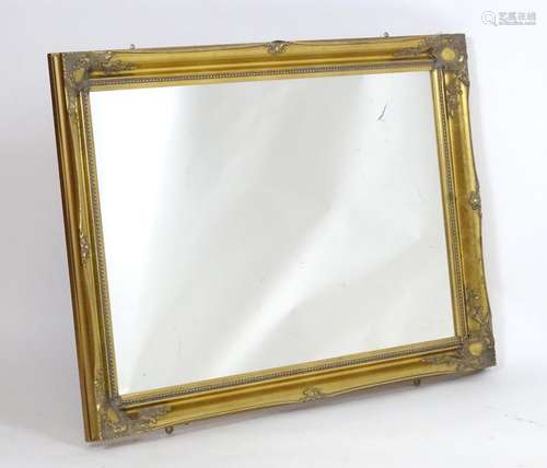 A 20thC mirror with a gilt frame, moulded surround and beaded decoration. 42