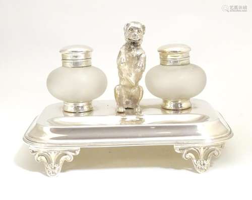 A silver plate desk standish with two glass inkwells and a model of a begging dog to centre. Approx.