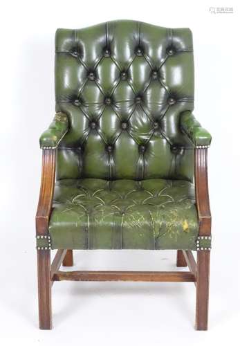 A late 20thC leather Gainsborough chair with deep buttoned leather upholstery and a mahogany