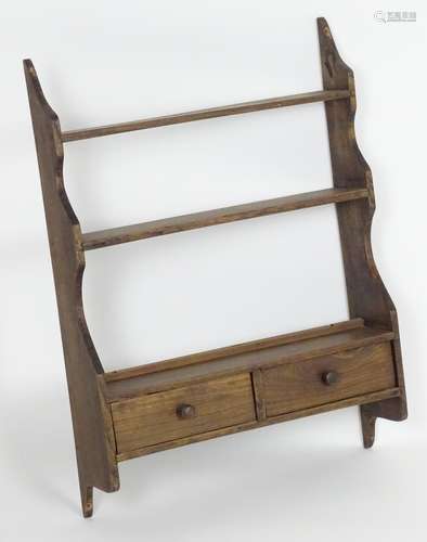 An early 20thC hanging spice rack of elm construction with to short shelves having turned wooden