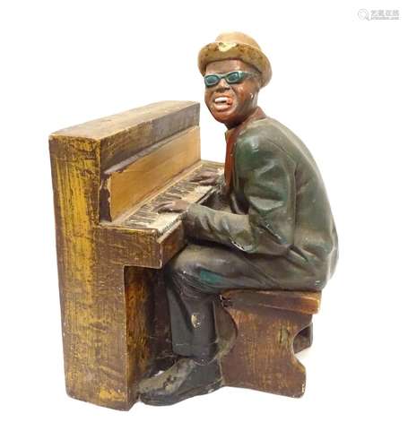 A 20thC model of a black gentleman playing the piano, possibly Ray Charles. Approx. 15 1/2