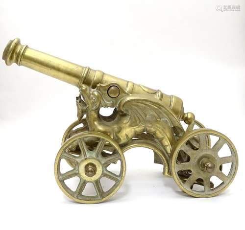 A 20thC brass desk / ornamental cannon, the chassis formed as dragons, 18