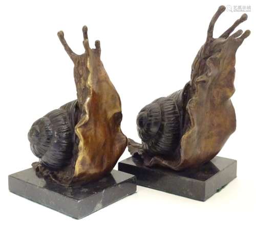 A pair of 20thC cast bronze bookends modelled as snails, each on a rectangular marble base