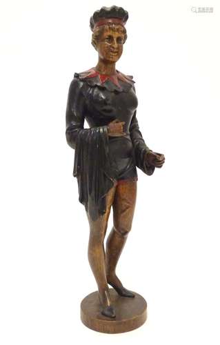 A 20thC carved wooden sculpture modelled as a woman wearing a jester style outfit with polychrome