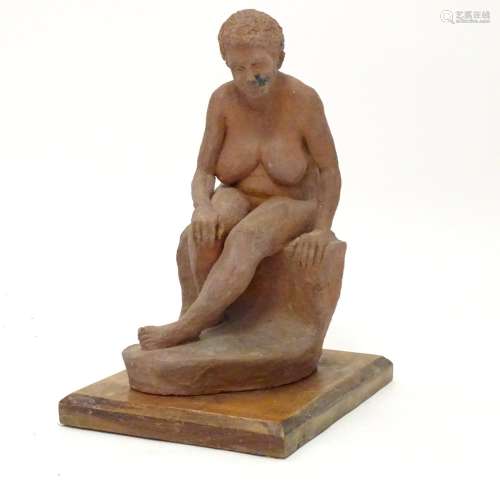 A 20thC clay sculpture modelled as a seated nude woman with short hair. On a wooden base. Approx. 11