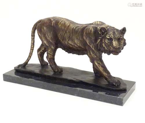 A 20thC cast bronze model of a prowling tiger, mounted on a rectangular marble base. Approx. 8 3/