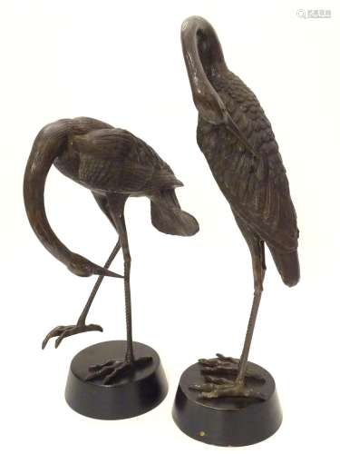 A 20thC cast bronze modelled as a crane bird, mounted on a circular wooden base. Together with