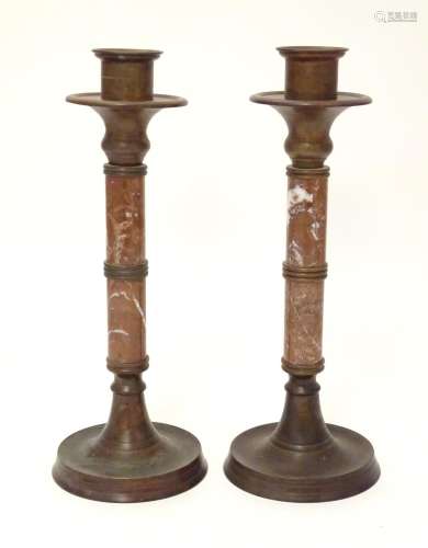 A pair of 20thC cast bronze candlesticks with marble columns. Approx. 16