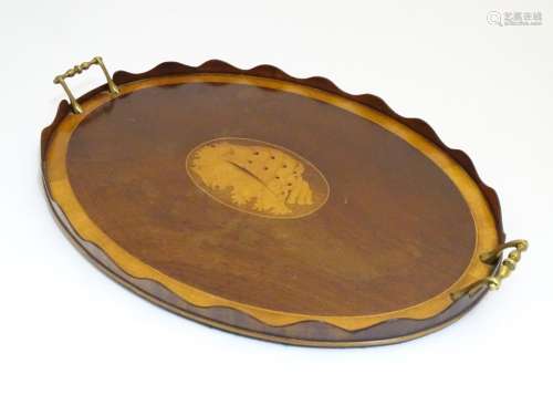 A late 19th / early 20thC oval mahogany tray with twin brass handles and central satinwood inlay