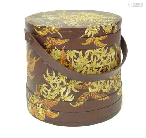 A 20thC wooden container of cylindrical form with a swing handle and hand painted floral and foliate