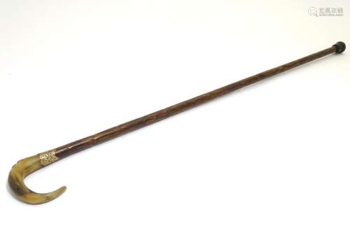 A 19thC walking stick, with rams horn handle, peacock wood shaft, brass embossed collar and rubber