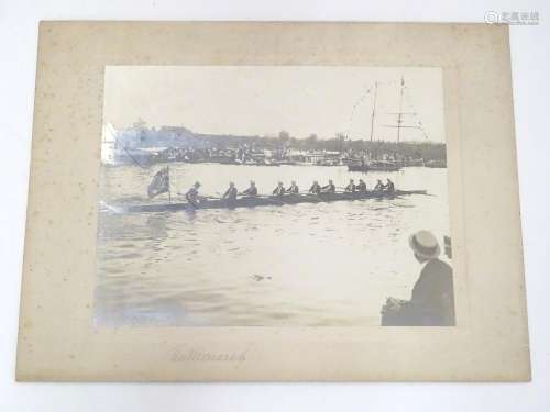 An early 20thC monochrome photograph depicting a rowing Regatta, a passing racing boat with crew