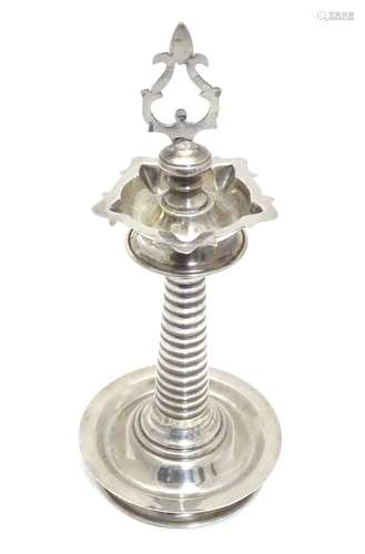 A white metal Indian Puja / Diya oil lamp, with 5 point reservoir to top, on a cylindrical stem with