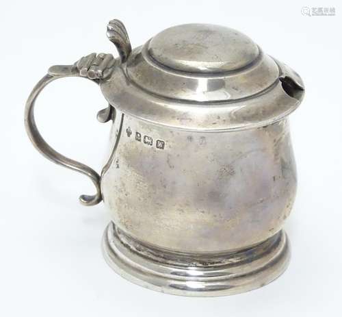 A silver mustard pot on stepped base, with blue glass liner within. Hallmarked Birmingham 1921 maker