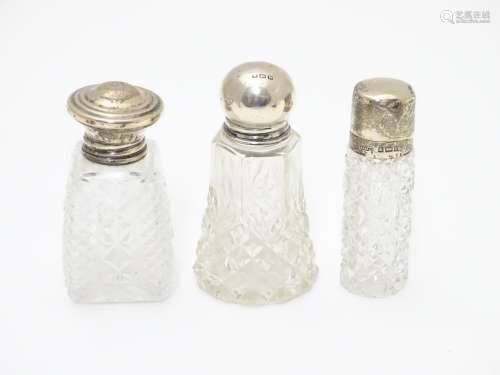 3 various cut glass perfume / scent bottles with silver tops. The tallest 3 1/2