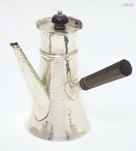 A silver chocolate pot with hammered decoration and ebonised handle. Hallmarked London 1909 maker