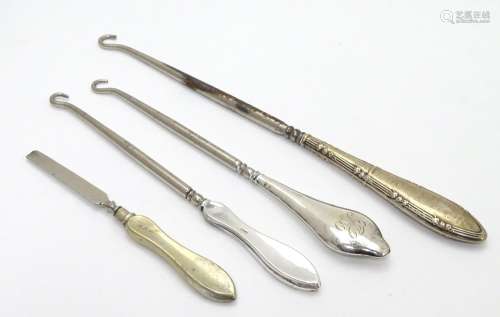 Three assorted button hooks with silver handles together with a manicure tool. The largest 8 3/4