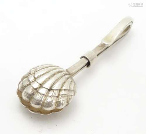 A white metal napkin clip with scallop shell formed grips. 2