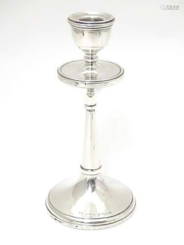 A silver candlestick hallmarked 1918 maker Napper & Davenport and marked with reg des no. 655179.