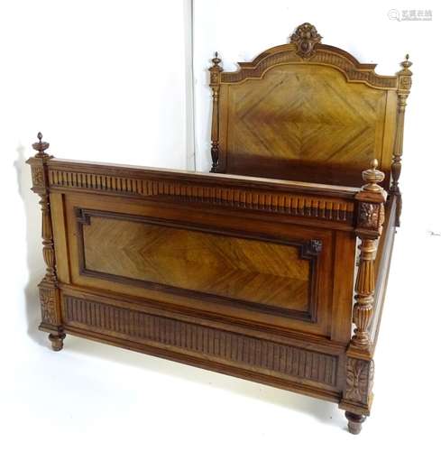 A late 19thC rosewood double bed with a carved shaped headboard mounted by turned finials and having