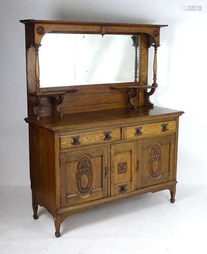 A late 19thC oak Art Nouveau dresser with a moulded cornice above a large mirrored back with twin