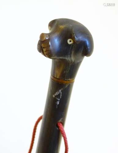 A 19thC carved horn handled fly swish, the knop carved as the head of a dog. Approx. 29