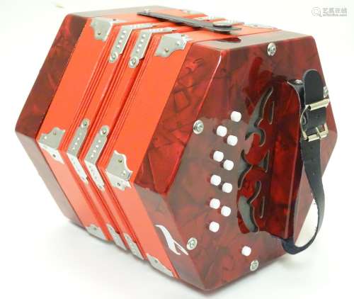 Musical Instrument: a late-20thC Concertina, in red finish with flight case, approximately 9