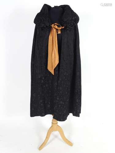 A bespoke vintage ladies black evening cape, with padded collar, tie to neck. Bronze/orange