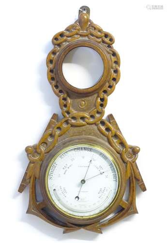 A Victorian aneroid barometer by Field & Son, Aylesbury, the carved oak case decorated with naval