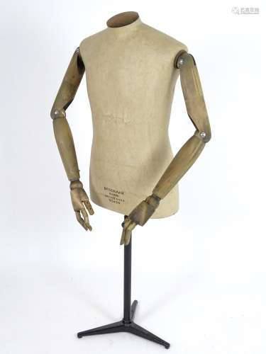 A Stockman Paris mannequin, with turned hardwood articulated limbs and cast iron tripod stand, 52