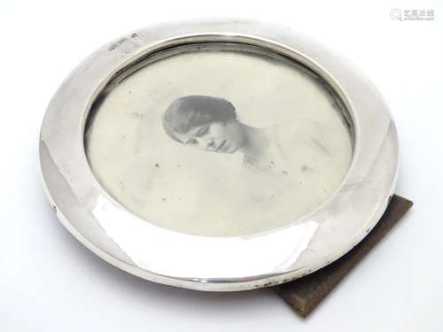 A photograph frame of circular form with silver surround. Hallmarked Birmingham 1916 maker William