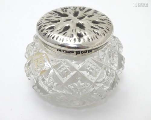 A cut glass pot with silver lid with textured decoration to top. Hallmarked Birmingham 1902 maker