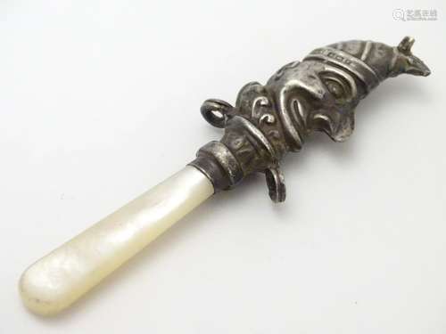 A child's rattle with mother of pearl teether and silver Mr Punch decoration. Hallmarked