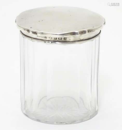 A glass jar with silver lid hallmarked Birmingham 1914 3 1/4