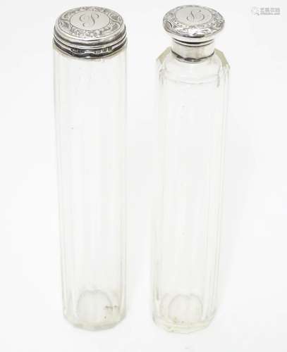 Two glass dressing table bottles with silver tops hallmarked London 1895. The tallest 7